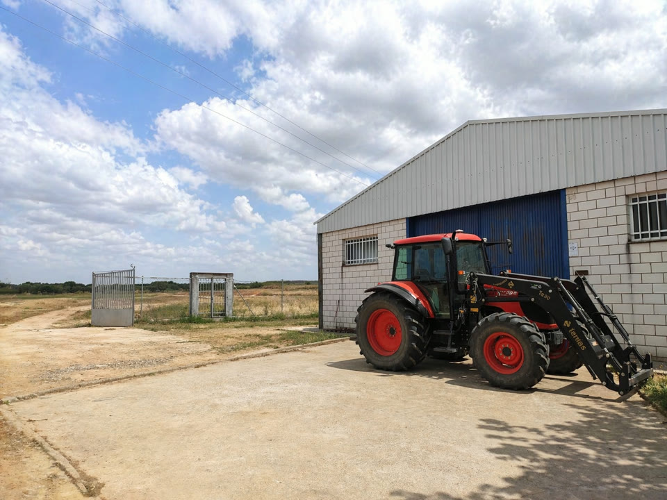 Maquinaria agrícola real disponible para prácticas: tractor y aperos en zona de taller.